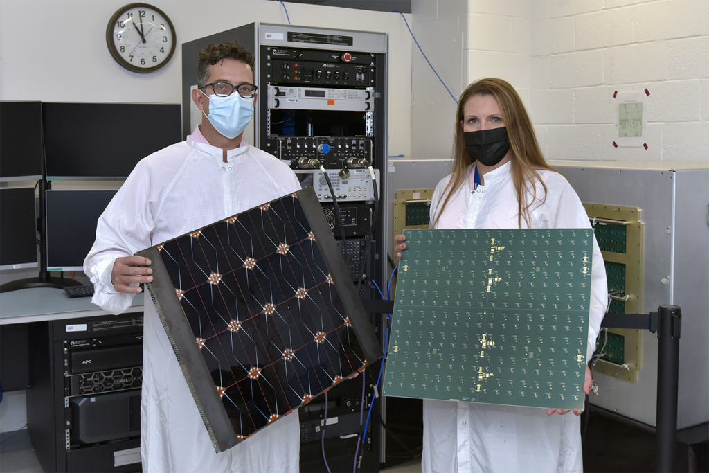 James Winter (AFRL) y Tara Theret (Northrop Grumman), directores del proyecto, sostienen modelos de los lados fotovoltaico y de radiofrecuencia del sándwich.