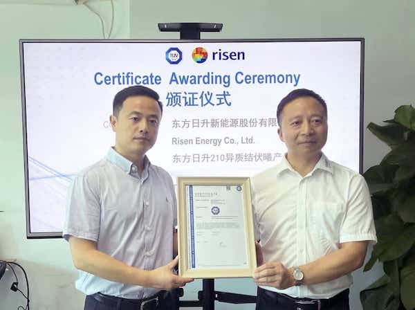 Hombres sujetando certificación de Risen Energy por el panel solar más potente de 700 W