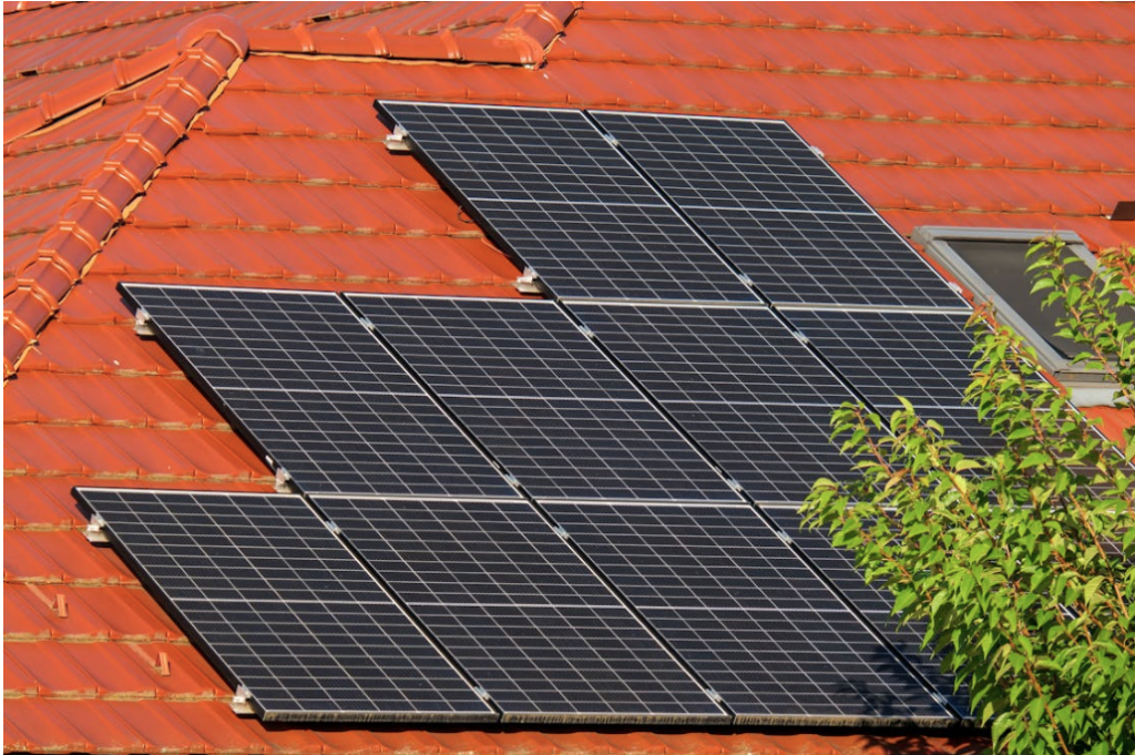 Trabajadores reparando paneles solares sobre el techo de una vivienda